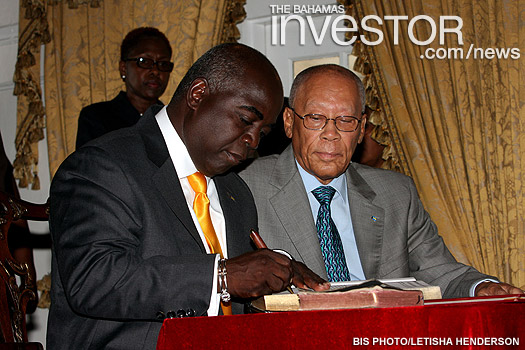 Philip Edward Davis signs documents during a ceremony