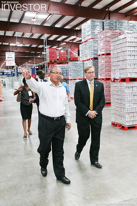 Minister of Financial Services Ryan Pinder (right) tours the new Coca-Cola plant July 19